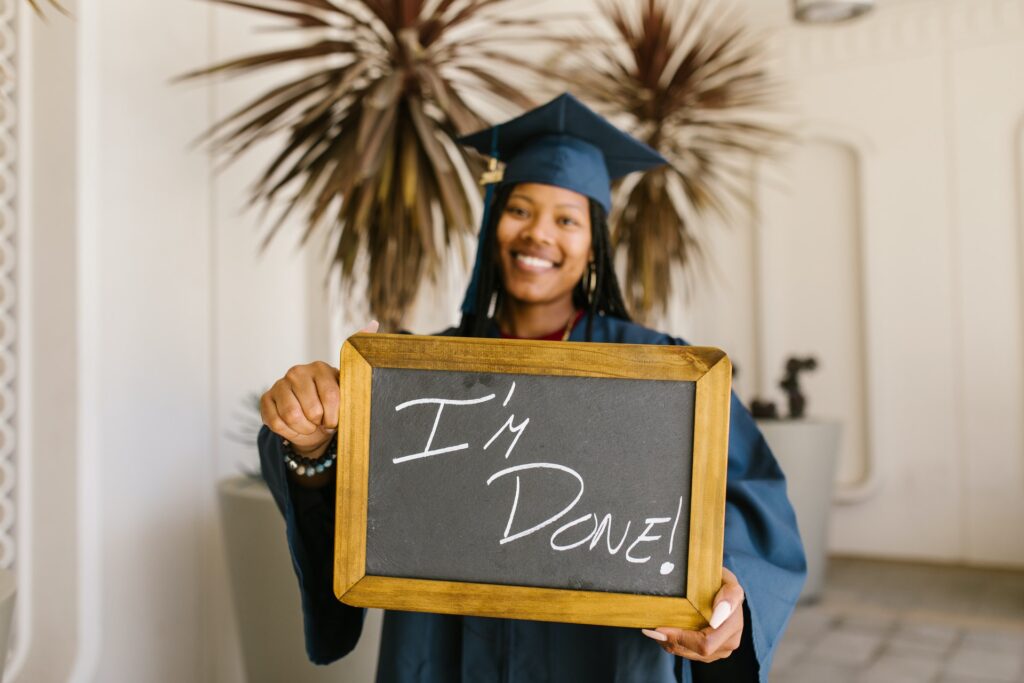 photo of recent grad with "i'm done" plaque graduation day