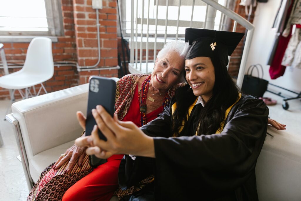 grandmom with grand daugher in cap and gown taking selfie