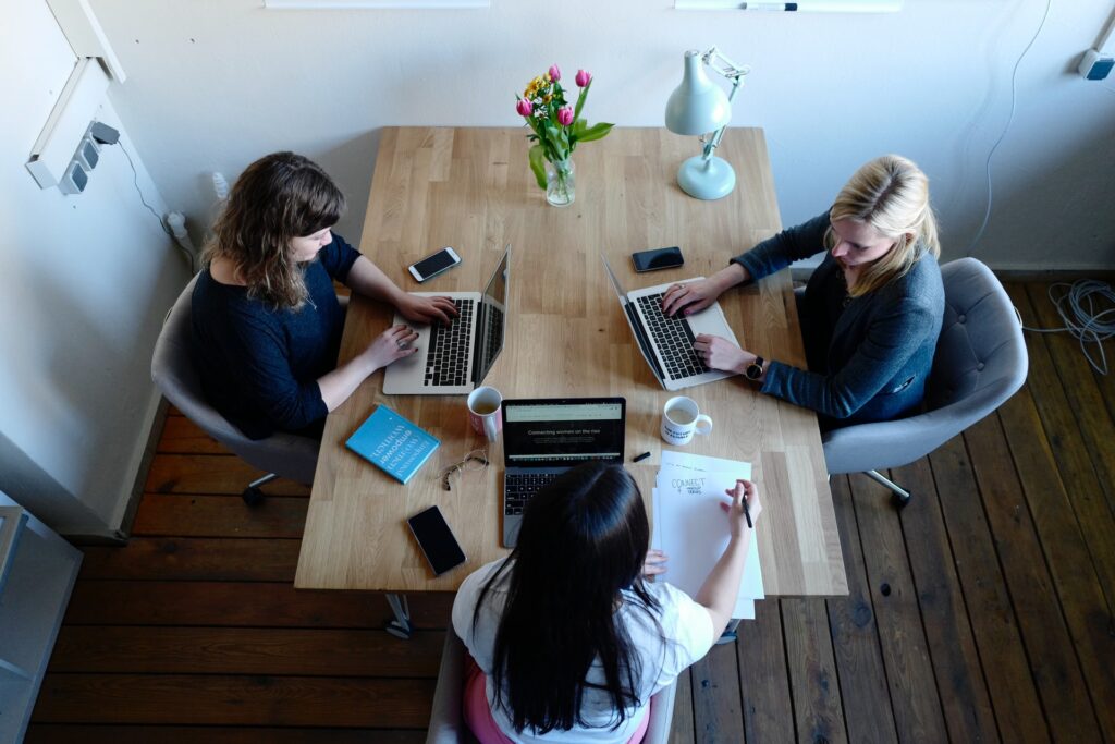 three women at table working on a business